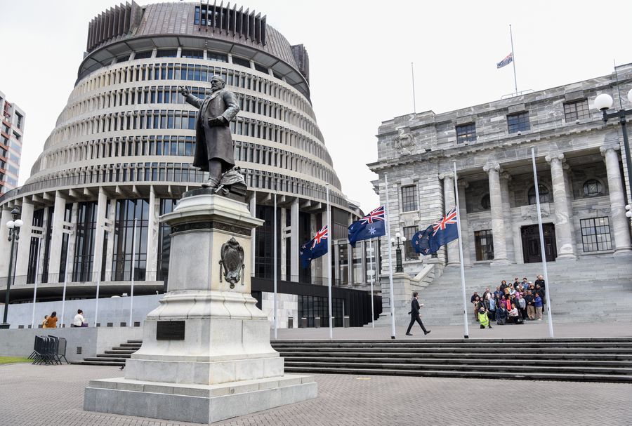 Des drapeaux de la Nouvelle-Zélande flottent en berne devant les édifices du Parlement pour rendre hommage aux victimes de l'éruption volcanique de White Island à Wellington, en Nouvelle-Zélande, le 16 décembre 2019. (Xinhua/Guo Lei)