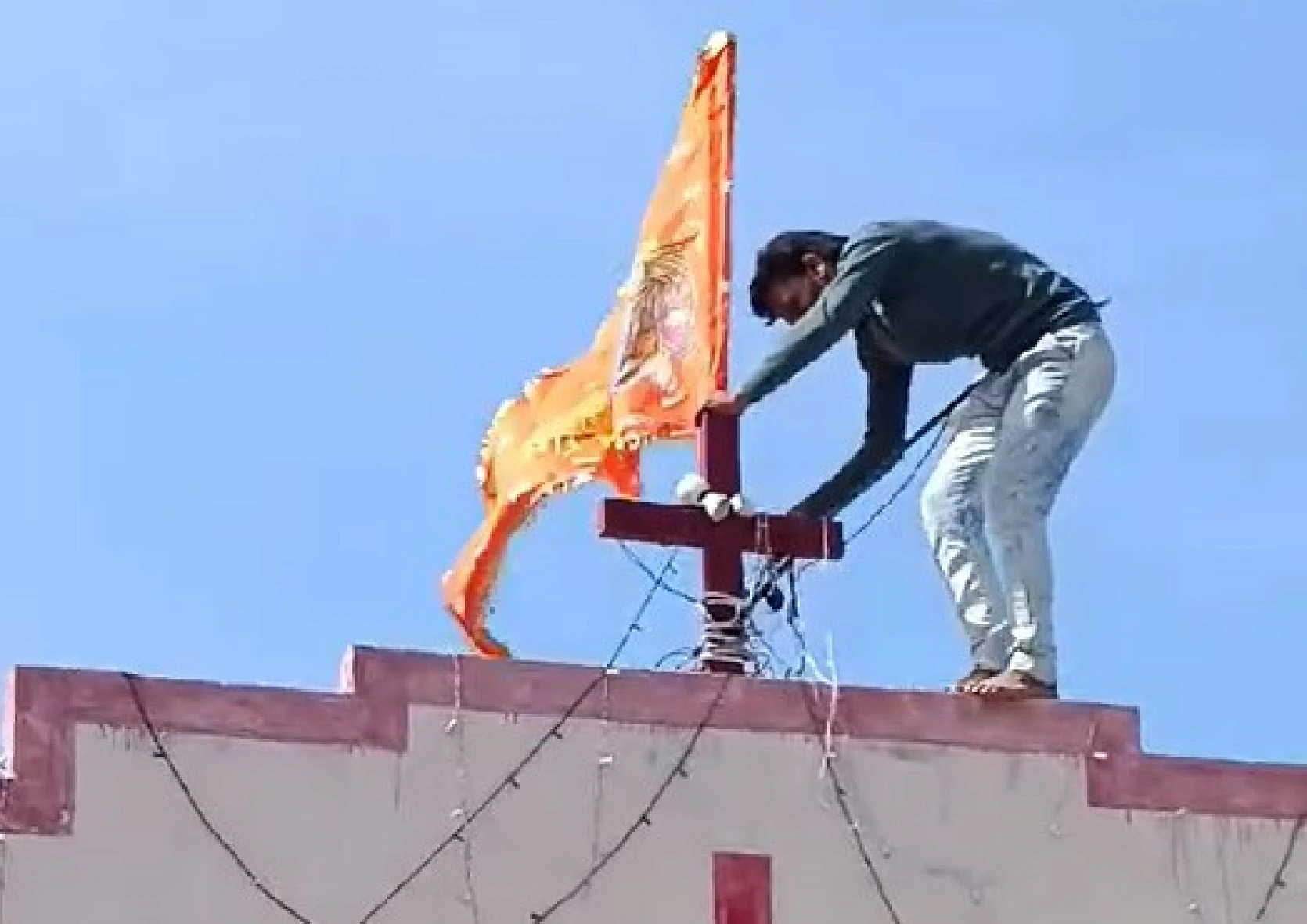Une provocation inutile pour les chrétiens : cet homme hisse un drapeau safran avec l’image de Lord Ram sur le toit d’une église. csi