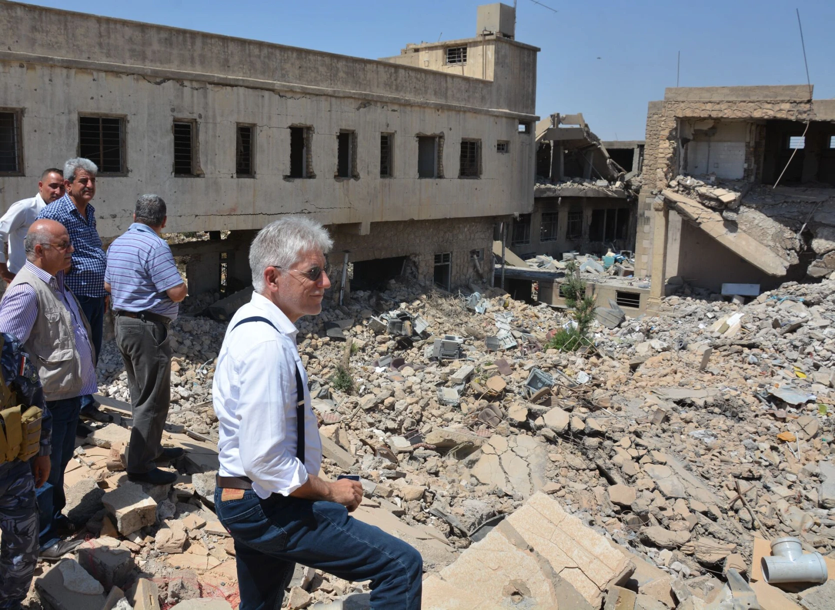 William Warda et John Eibner avec des collaborateurs d’Hammurabi devant le monastère détruit de Sainte-Catherine à Mossoul en 2017, peu après la reprise de la ville par l’armée irakienne. csi