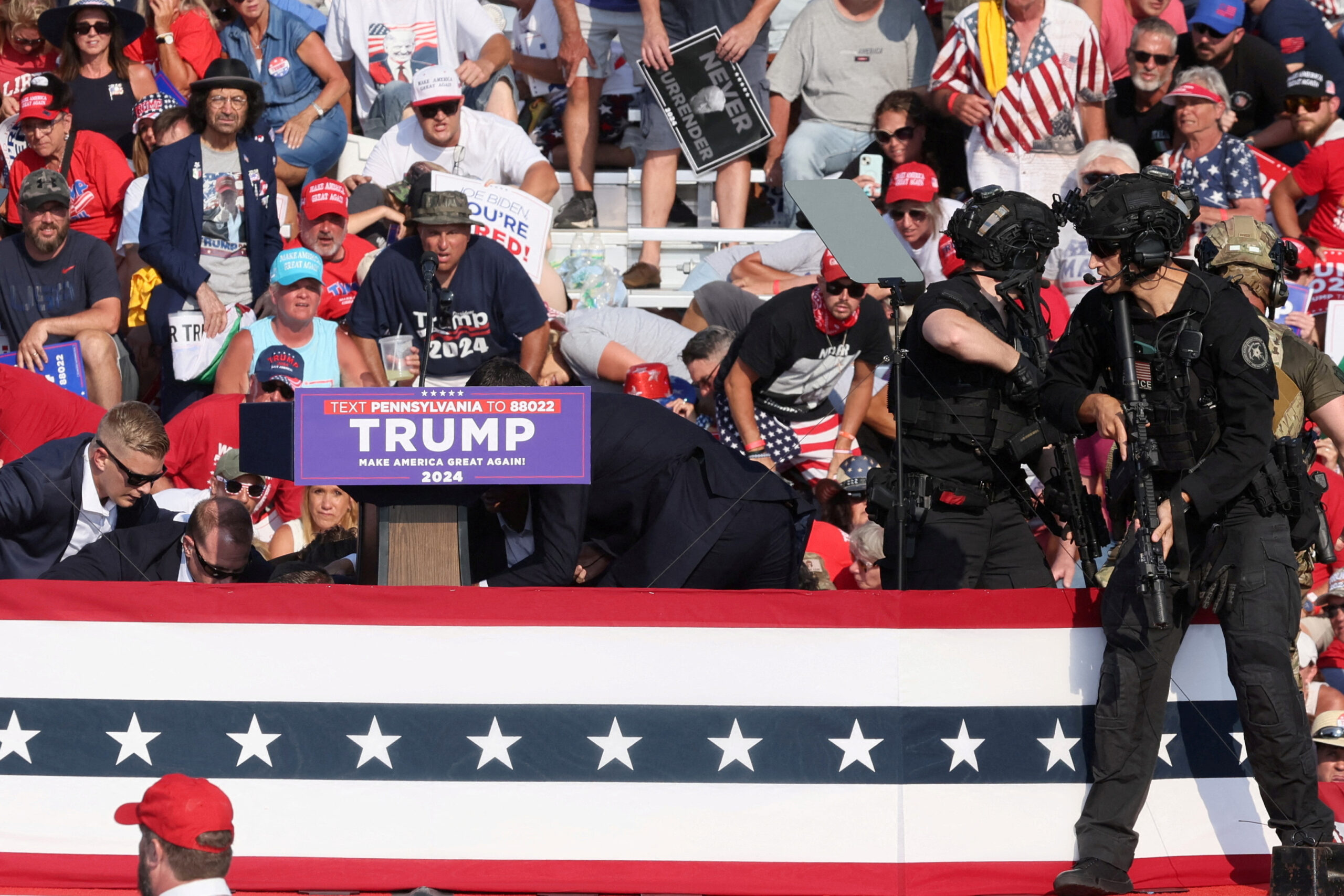 Le candidat républicain à la présidence et ancien président des États-Unis Donald Trump est aidé par le personnel des services secrets américains après que des coups de feu ont retenti lors d'un rassemblement de campagne au Butler Farm Show à Butler, Pennsylvanie, États-Unis, 13 juillet 2024. REUTERS/Brendan McDermid