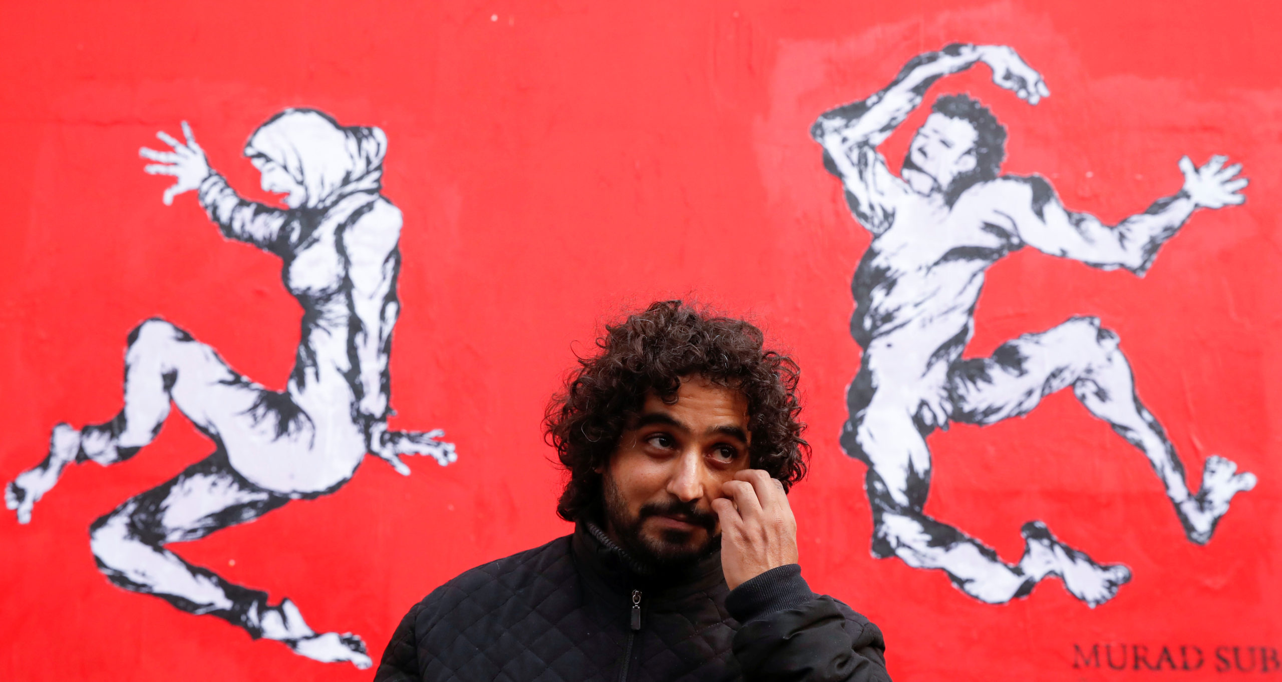 "Sur le corps des Yéménites, passent la guerre, l'hypocrisie internationale et les armes" : l'artiste Murad Subay, surnommé le "Banksy du Yémen", a dévoilé mardi à Paris une fresque murale de trois mètres de haut (en photo) qui dénonce, sur fond rouge, la vente d'armes françaises à la coalition qui intervient militairement dans son pays. /Photo prise le 19 novembre 2019/REUTERS/Christian Hartmann