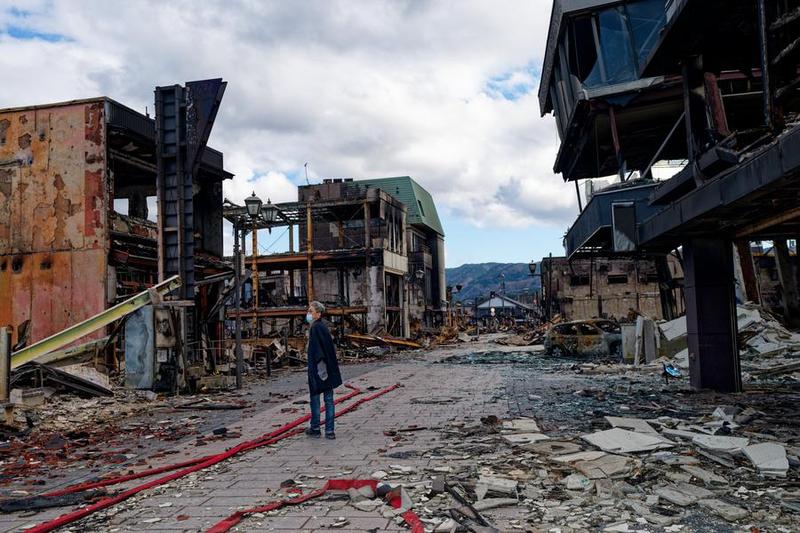 Une personne devant les décombres d'un célèbre marché matinal à Wajima dans la préfecture japonaise d'Ishikawa (centre), le 4 janvier 2024. (Xinhua/Zhang Xiaoyu)