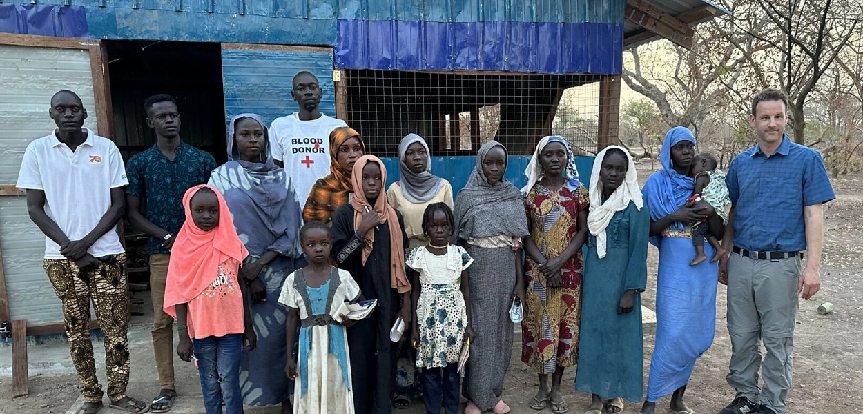 Un groupe de réfugiés chrétiens dans le camp de réfugiés de l’ONU avec Abdalla (tout à gauche) et Simon Brechbühl (tout à droite). csi