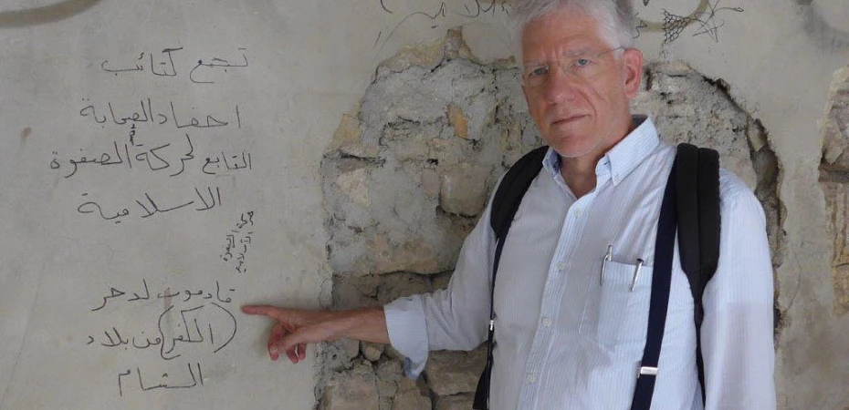 Peu après l’expulsion des djihadistes en 2017, le Dr John Eibner, président international de CSI, s’est rendu à Alep. Il montre ici un graffiti écrit en arabe : « Nous venons pour chasser l’incrédulité de la terre de Syrie. » csi