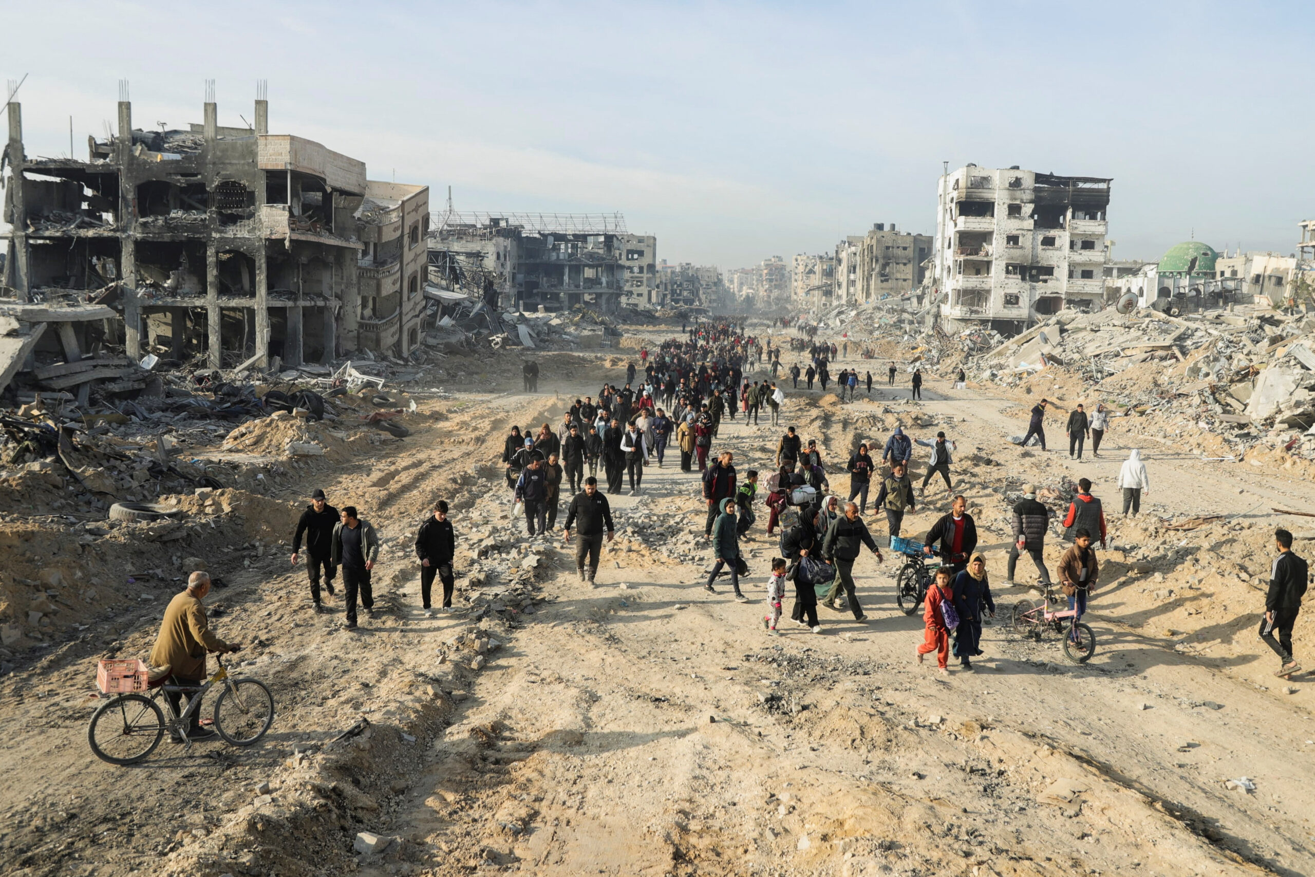 Des Palestiniens déplacés passent devant les décombres alors qu'ils retournent chez eux le jour de l'entrée en vigueur d'un cessez-le-feu entre Israël et le Hamas, dans le nord de la bande de Gaza/Photo prise le 19 janvier 2025/REUTERS/Khalil Ramzi