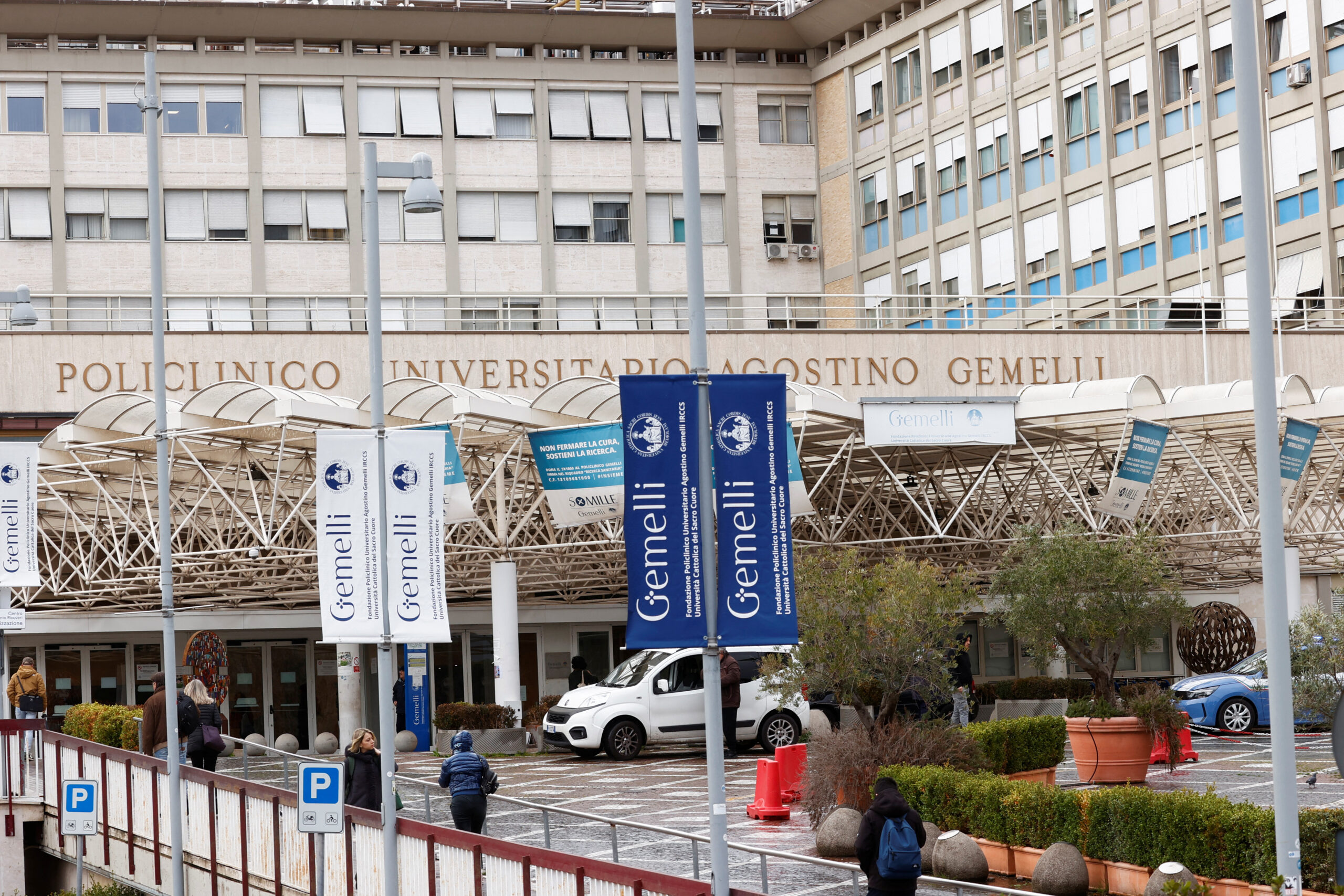 Des personnes marchent devant l'hôpital Gemelli où le pape François est hospitalisé à Rome, Italie. /Photo prise de 15 février 2025/REUTERS/Ciro De Luca